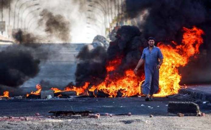 بستن خیابان با آتش زدن تایر از سوی معترضان به دولت در شهر بصره در جنوب عراق / خبرگزاری فرانسه