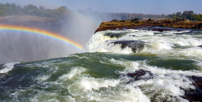  آبشار ویکتوریا در زامبیا
زامبیا یک کشور آفریقایی است که طبیعت نابی را در خود جای داده است. یکی از اماکن دیدنی زامبیا آبشار ویکتوریا و استخر شیاطین می‌باشد که به دلیل زیبایی بی‌نظیرش در فهرست امروز ما قرار گرفته است. باید بدانید که آبشار ویکتوریا لقب مرتفع‌ترین آبشار دنیا را به دوش می‌کشد به همین خاطر حتما ارزش بازدید را دارد. آبشار ویکتوریا و استخر طبیعی آن تا سالهای زیادی از چشمان مردم جهان پنهان شده بود اما حالا به یکی از چالش ‌برانگیزترین مکان‌های دنیا برای گردشگران ماجراجو تبدیل شده است.
