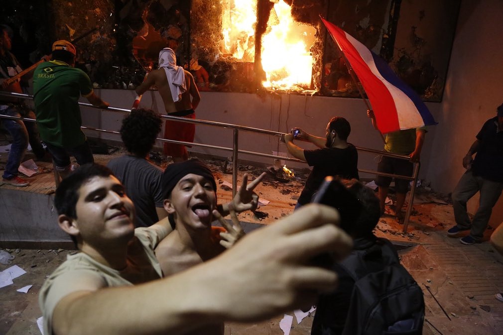 عکس/ سلفی با ساختمان به آتش کشیده شده پارلمان پاراگوئه