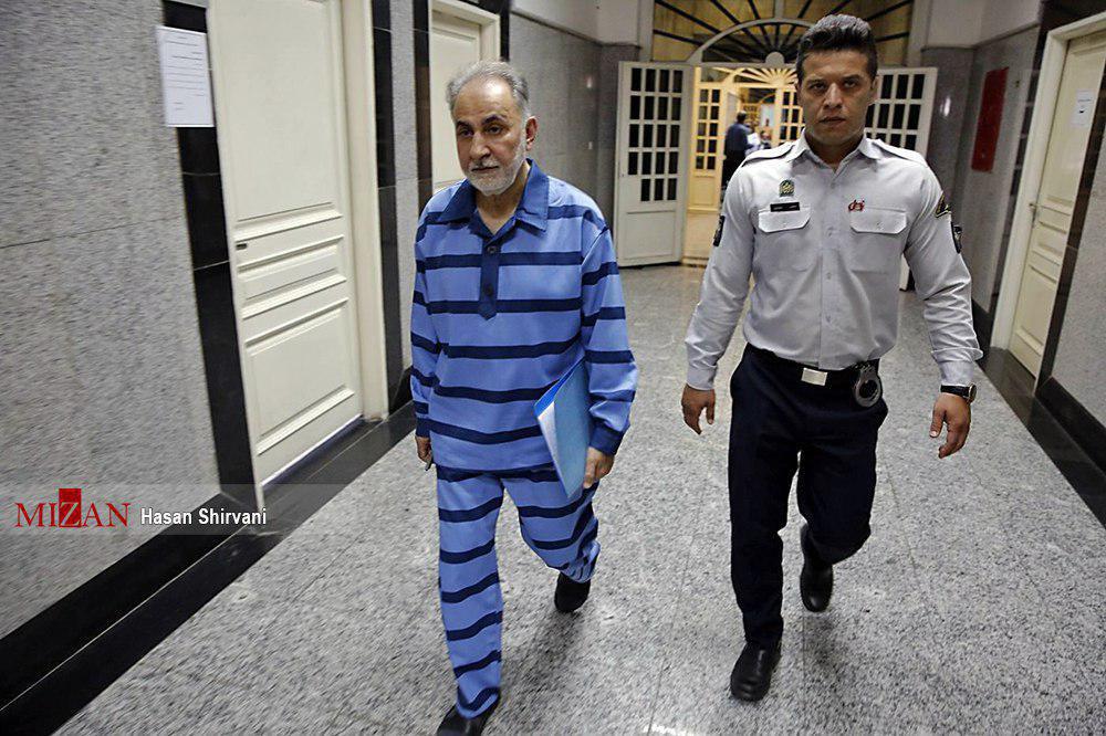 نجفی با پرونده‌ای آبی در دست، وارد دادگاه شد