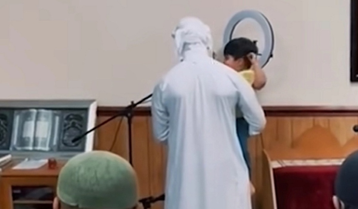 فیلم| یک کودک در آغوش امام جماعت درحال اقامه نماز