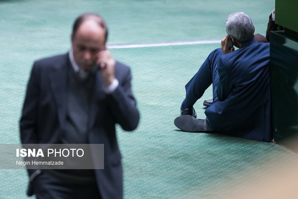 عکس| قابی عجیب در صحن علنی مجلس؛ تلفن حرف زدن روی زمین و تکیه به جایگاه!