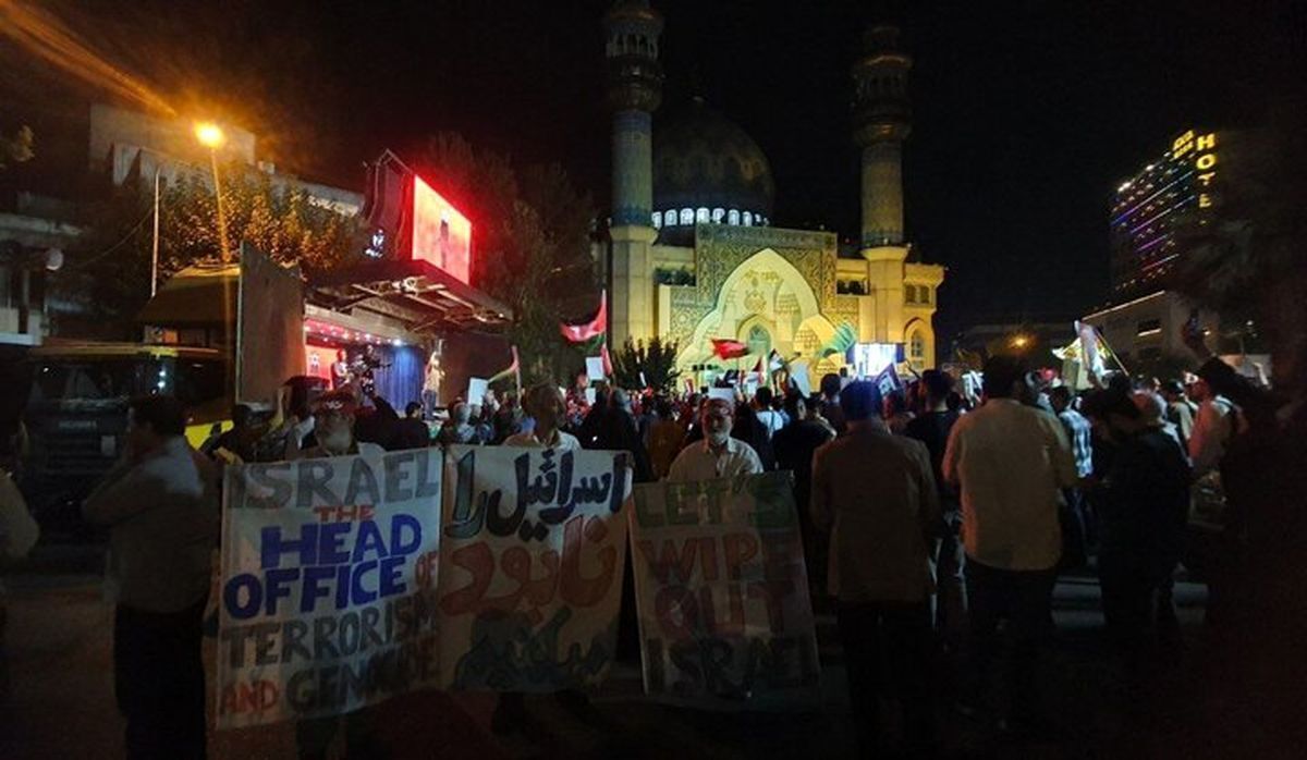 عکس| حجاب منشوری زن طرفدار فلسطین که عکس سردارسلیمانی را در دست دارد