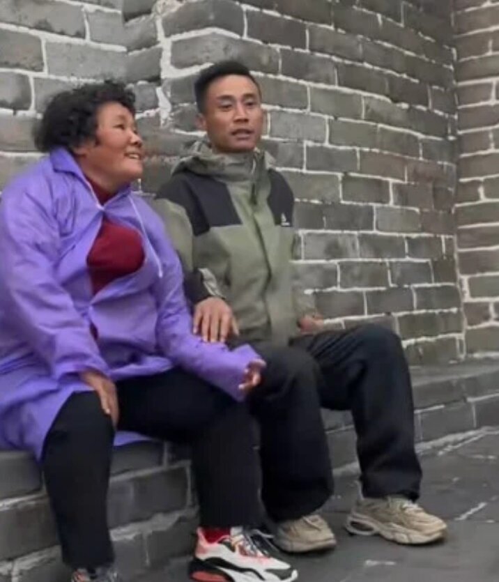 عکس/ فداکاری عجیب مرد چینی؛ مادر معلولش را کول گرفت و به سفر برد