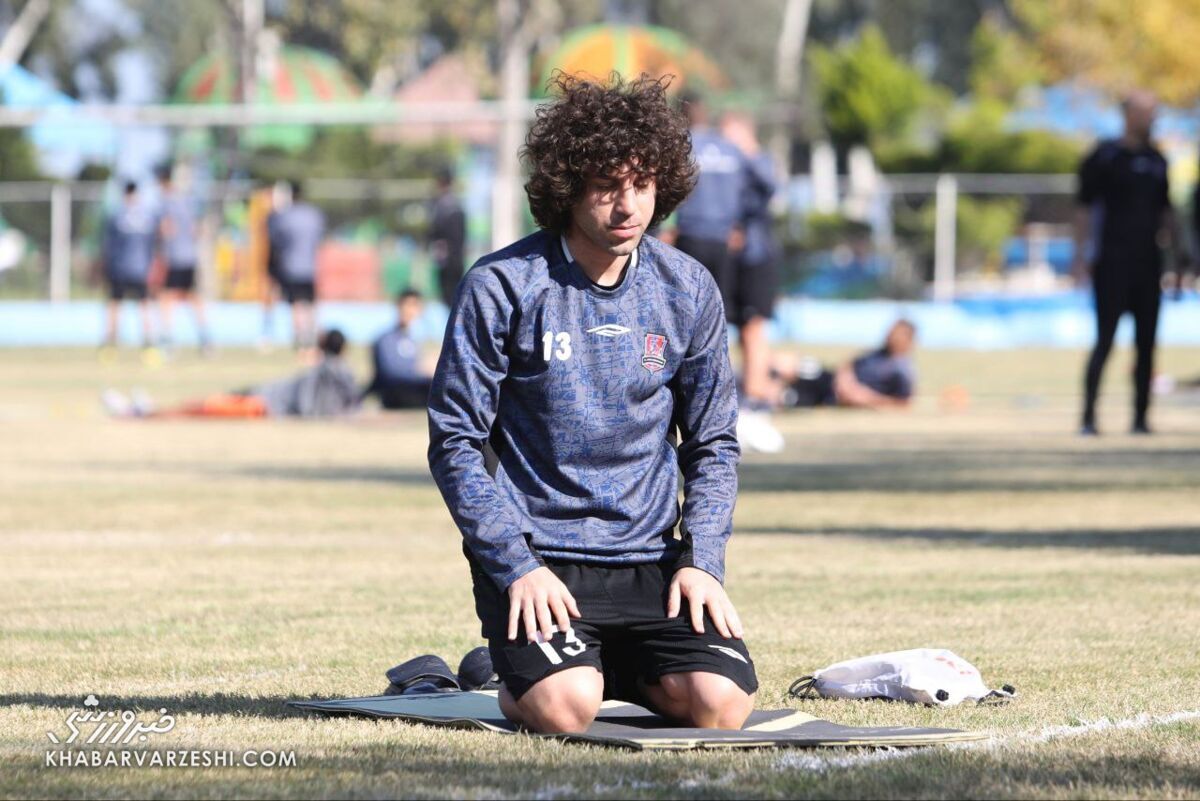 عکس/ نماز اول وقت منتظر محمد در حاشیه تمرین؛ راز و نیاز ستاره عراقی وسط زمین فوتبال