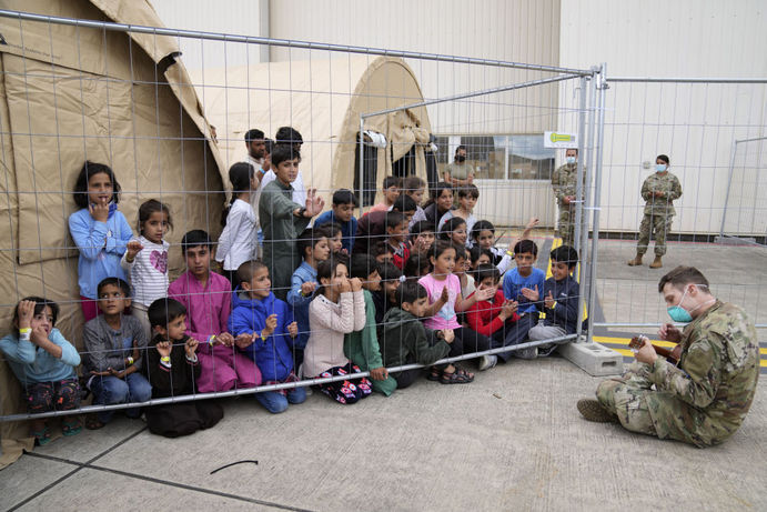 گیتار نوازی سرباز آمریکایی برای کودکان پناهجوی افغان در پایگاه هوایی رامشتاین در آلمان
